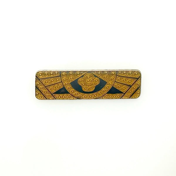 A vintage rectangular Art Deco revival bar brooch in the Pierre Bex style, featuring textured gold-tone metal sunburst rays, dark enamel details, and a central floral cloud medallion against a solid white background