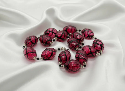 Express your unique style with this stunning Vintage Clear Magenta and Black Striped Blown Glass Beads Necklace. Its cool and smooth touch will captivate your senses, while the mesmerizing dark swirls add a touch of mystery and intrigue.