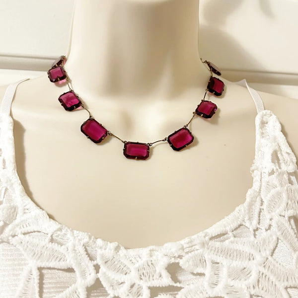 Admire the timeless beauty of our Graceful Vintage Czech Violet Clear Stones Necklace. Handcrafted with thirteen emerald cut purple clear stones encased in intricately detailed frames, this elegant necklace is a true work of art. With a length of approximately 15", it is a delicate and sophisticated addition to any outfit. Experience luxury and exclusivity with this exquisite piece, in immaculate condition.