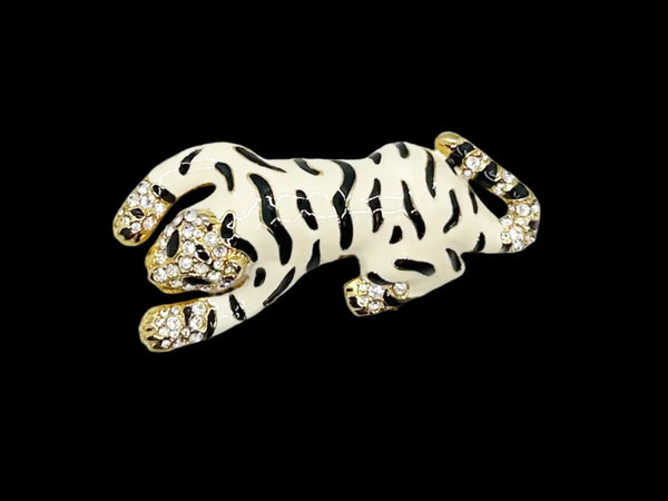This vintage white tiger brooch makes quite a statement! It has rich cream-white enamel accented by black enamel stripes. The face, paws and tail are covered in bright white pave set rhinestones, and it has black enamel eyes. The tiger brooch measures 3.25" long and is in very good condition.