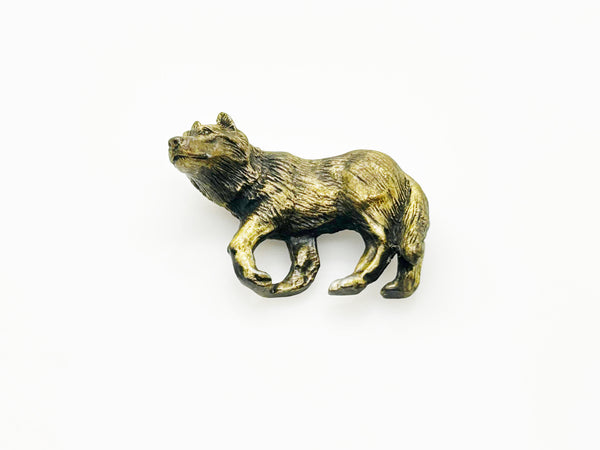 Antiqued bronze wolf brooch pin with highly detailed textured fur on a plain white background