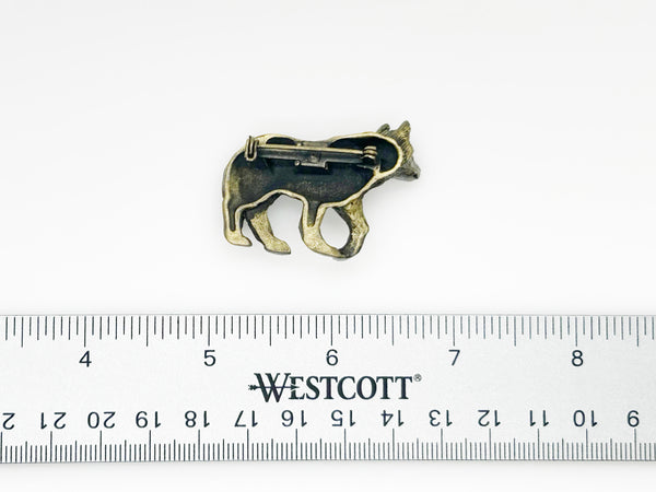 Antiqued bronze wolf brooch pin with highly detailed textured fur on a plain white background